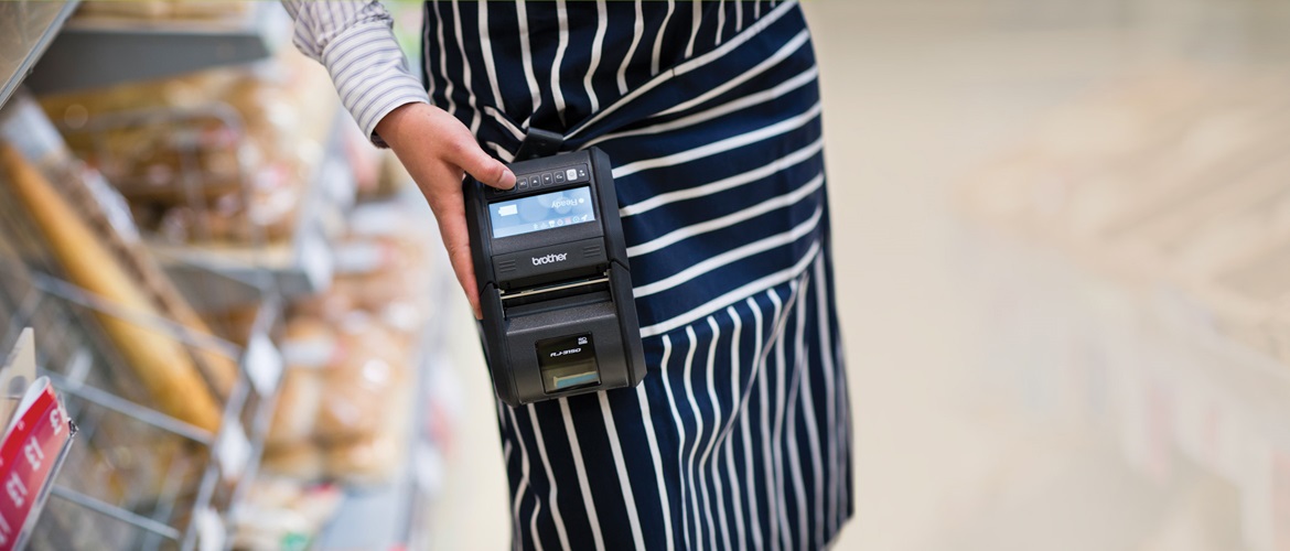 Maloobchodní pracovník nese zařízení Brother RJ-3150 v obchodním prostoru