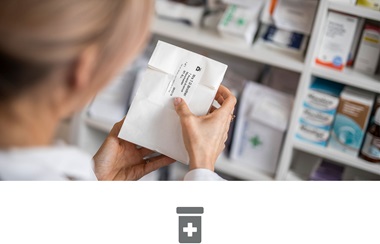 Magistra v lékárne lepí štítek na léky